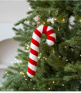 Close-up of a red and white glittery candy cane ornament hanging on a Christmas tree