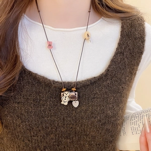 Close-up of vintage multi-pendant necklace with cute bear and coffee bean charms