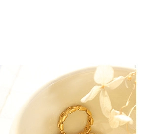 Gros plan détaillé d'une bague chaîne en acier titane doré avec maillons en H ajourés