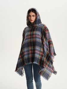 Detail of hooded plaid poncho featuring Scottish check pattern and soft fringe edges