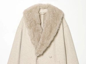 Detailed view of beige coat featuring a soft faux fur collar and wool blend texture