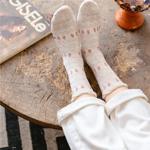 Cute strawberry pattern cotton socks in beige, mid-calf length shown on a wooden table