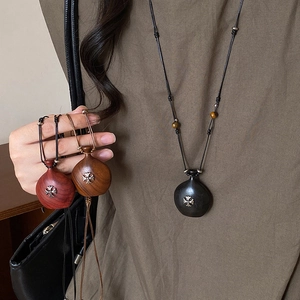 Détail de pendentifs en bois avec croix gothique en métal sur cordons de cire réglables