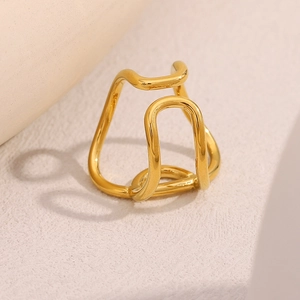 Detailed view of an 18K gold plated stainless steel knotted ring on a textured surface