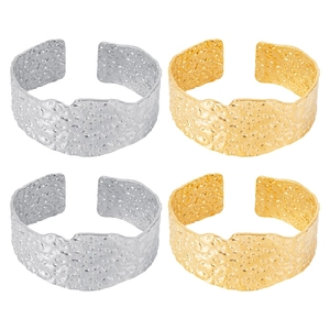 Detailed view of wide open cuffs with hammered rock texture in gold and silver finish
