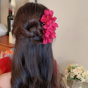 Detail view of pink fabric floral hair pin with layered petals in French romantic style