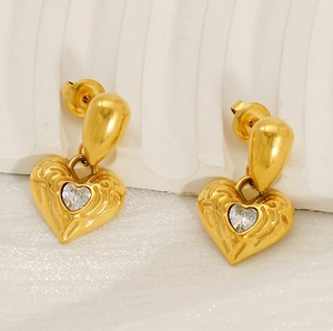 Detail of 18k gold plated hammered heart earrings with a central clear zircon stone