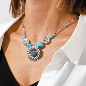 Close-up of Bohemian necklace with sunflower pendant and turquoise beads on model