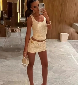Close-up of sparkling beige gold sequins on the cropped camisole and mini skirt set