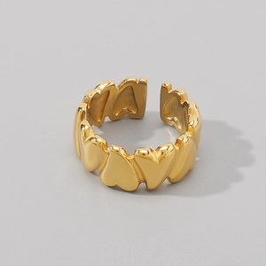 Detail of the adjustable golden stainless steel ring featuring a continuous heart pattern