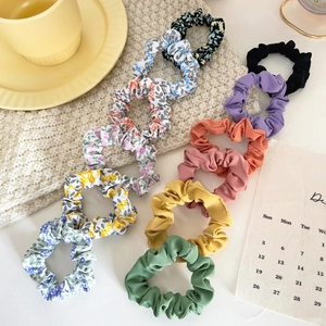 Detail of 10-piece set featuring satin scrunchies in solid colors and floral patterns