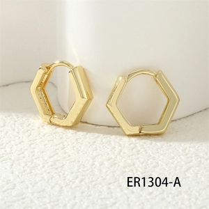Macro view of 18K gold hexagonal hoop earrings with polished mirror finish and latch back