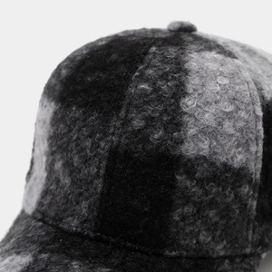 Gros plan sur la texture épaisse en polaire à carreaux d'une casquette d'hiver