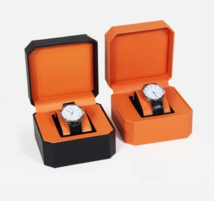 Detail view of octagonal PU leather watch boxes in black and orange with soft interior cushions