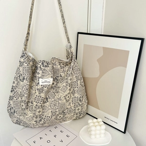Detail of paisley pattern cotton tote bag next to home decor items on a table