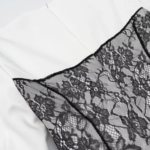Detailed close-up of premium white woven fabric stitched with black floral lace pattern