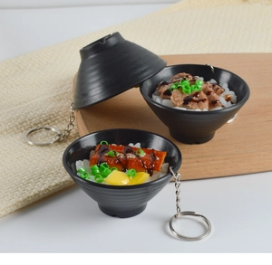 Macro detail of miniature Japanese eel bowl keychains with realistic texture and metal ring