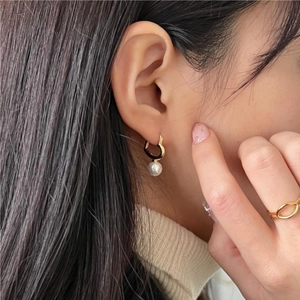 925 silver heart hoop earrings with white pearl pendant on elegant female model