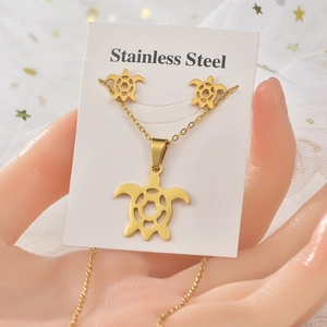 Detailed view of a gold-plated stainless steel turtle necklace and earrings jewelry set
