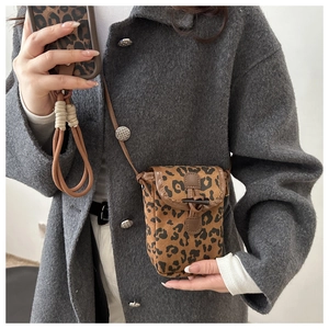 Detail of leopard print crossbody bag featuring vintage horn buckle and leather trim