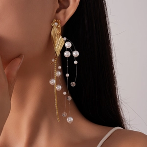 Detail of vintage flower leaf earrings with tassels, pearls and crystals on a model