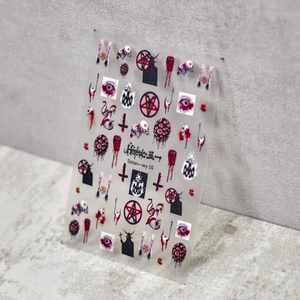 Detail of gothic nail art stickers featuring skulls, bleeding eyes, and satanic symbols