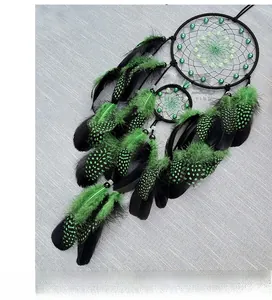 Detail of handmade glowing dream catcher with green and black feathers and beadwork