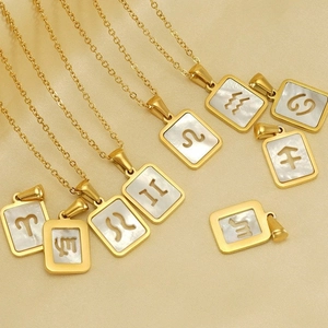 Gold 18K stainless steel 12 Zodiac necklaces with white shell inlay on beige fabric