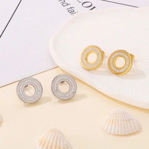 Detail view of gold and silver open circle stud earrings with pavé crystal accents