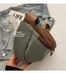 Detail view of multi-color nylon dumpling bag with adjustable strap in urban lifestyle setting