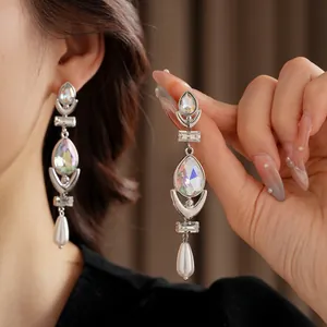 Luxury silver-toned long drop earrings with waterdrop crystals and pearls on a model