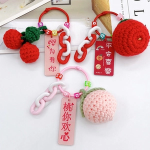 Detail of handmade crochet fruit charms with cherry and apple shapes on beaded straps