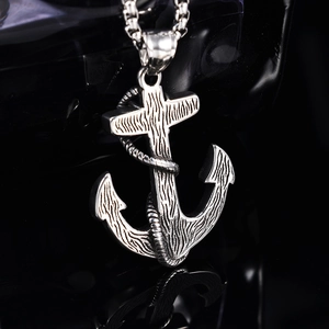Vintage stainless steel anchor necklace with detailed wood grain texture on black background