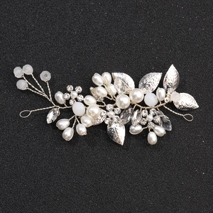 Macro detail of silver bridal hair vine with crystal rhinestones, pearls and leaves