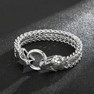 Macro detail of double snake head vintage steel bracelet with woven wheat chain texture