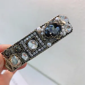 Detail of vintage hairpin with black gemstone, rhinestones and pearls on gold base