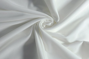 Close-up of the elegant white pleated fabric texture and soft drape of the dress