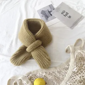 Detail of ginger knitted baby scarf showing thick ribbed texture and cross-loop design