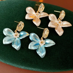 Detailed macro shot of blue and champagne pearl flower earrings with crystal accents