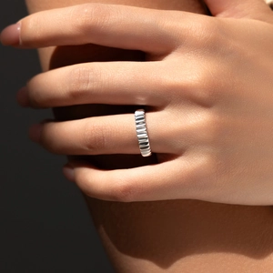 Industrial style S925 sterling silver ring with rippled texture on model finger