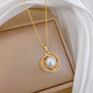 Close-up of bird nest necklace pendant featuring pearl and sparkling zircon details