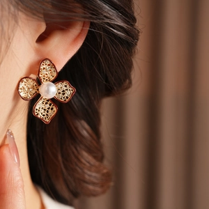 Details des Vintage-Blumenohrrings mit goldenen Blütenblättern und einer Perle