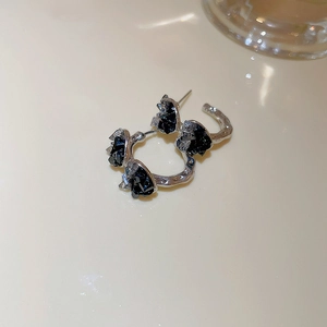 Macro detail of silver earrings featuring micro-set black crystals and elegant design