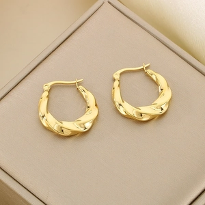 Detail shot of golden twisted rope texture on hollow U-shaped stainless steel earrings