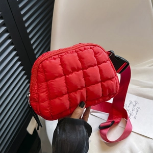Detailed view of red quilted nylon crossbody waist bag with adjustable wide strap and buckle