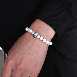 Close-up of marble texture beads bracelet with a silver skull charm on a male wrist