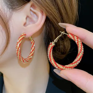 Sparkling gold-toned spiral hoop earrings with red and clear crystal pavé detailing