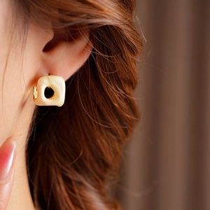 Detail of vintage square beige marble resin earrings with gold circular hollow cut-out