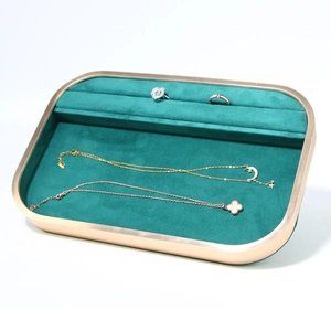 Detail view of emerald green velvet jewelry tray with a champagne gold metal frame