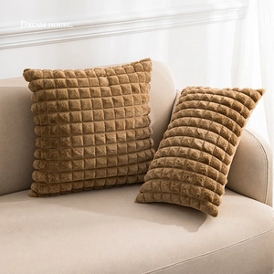 Faux rabbit fur checkered throw pillows in warm brown, set of two on beige sofa